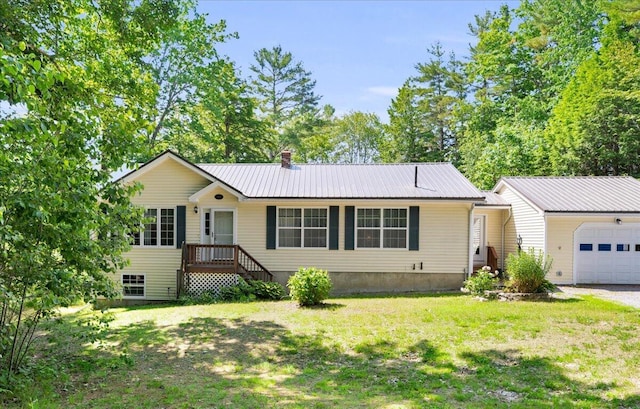 95 The Woods Rd, Union, ME 04862 - ranch-style house featuring a metal roof, a front yard, a chimney, and a garage