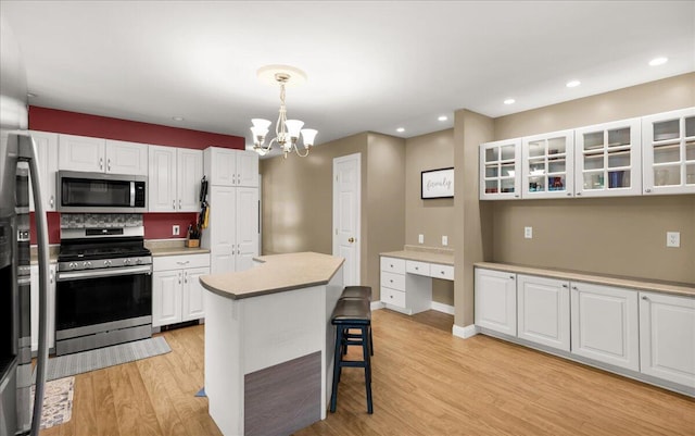 95 The Woods Rd, Union, ME 04862 - kitchen with appliances with stainless steel finishes, a chandelier, white cabinetry, light wood-style floors, and recessed lighting
