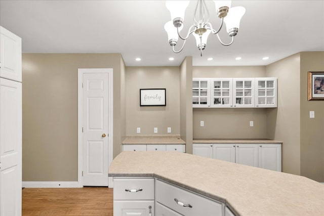 95 The Woods Rd, Union, ME 04862 - kitchen featuring light wood-style floors, a chandelier, white cabinetry, light countertops, and glass insert cabinets