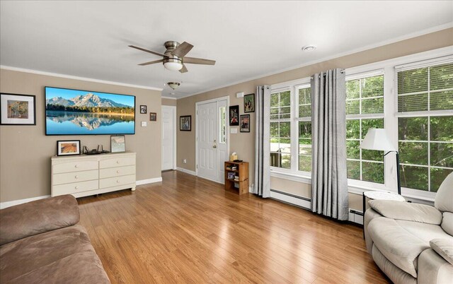 95 The Woods Rd, Union, ME 04862 - living room with wood finished floors, ornamental molding, a ceiling fan, and a baseboard heating unit