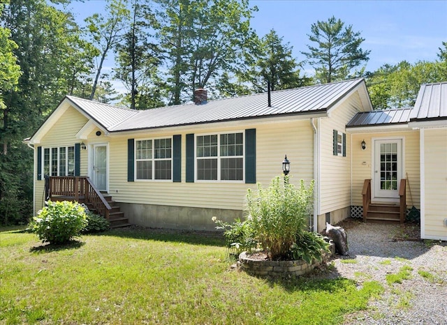 95 The Woods Rd, Union, ME 04862 - view of front of home featuring entry steps, a front yard, a chimney, and a metal roof