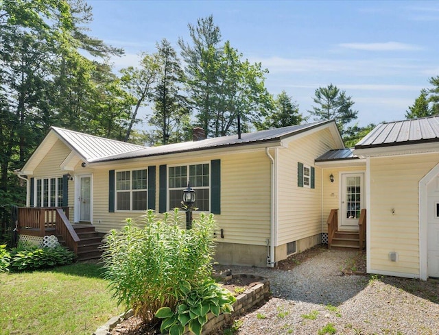 95 The Woods Rd, Union, ME 04862 - view of front of home with entry steps, a metal roof, a chimney, and a deck
