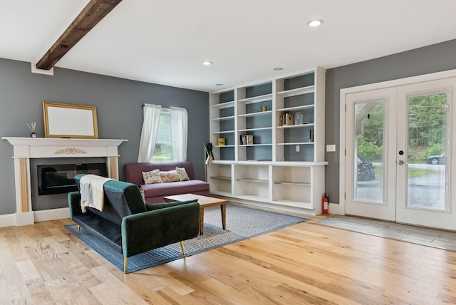 1228 Long Plains Rd, Buxton, ME 04093 - living area with french doors, wood finished floors, a glass covered fireplace, recessed lighting, and beam ceiling