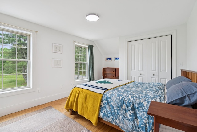 1228 Long Plains Rd, Buxton, ME 04093 - bedroom with light wood-type flooring, a closet, and vaulted ceiling