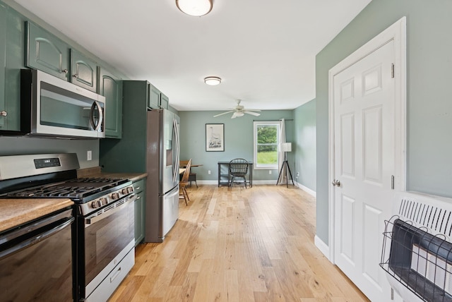 1228 Long Plains Rd, Buxton, ME 04093 - kitchen with appliances with stainless steel finishes, green cabinetry, heating unit, light wood-type flooring, and ceiling fan