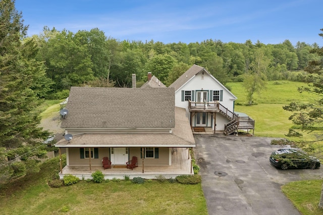 1228 Long Plains Rd, Buxton, ME 04093 - view of front facade with covered porch, stairway, a wooded view, roof with shingles, and asphalt driveway