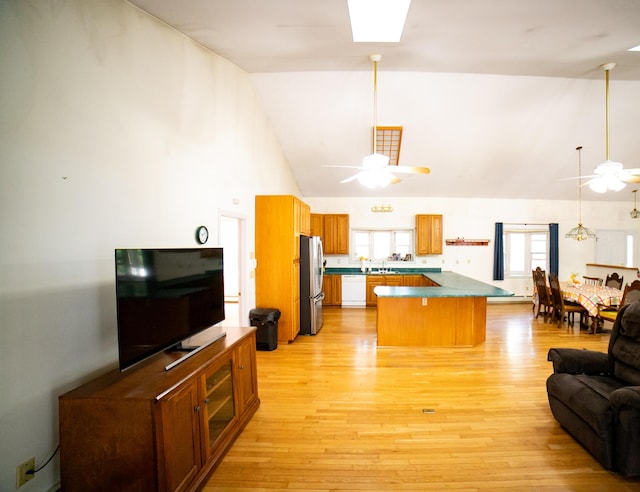 kitchen with white dishwasher, a sink, high vaulted ceiling, freestanding refrigerator, and a ceiling fan