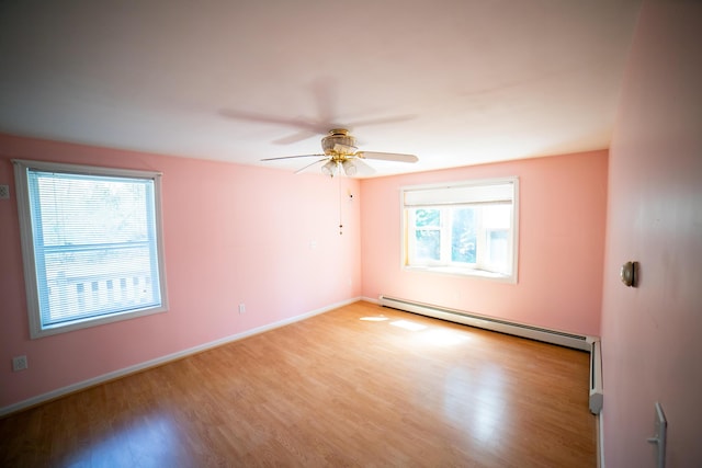unfurnished room featuring baseboards, ceiling fan, a baseboard heating unit, and light wood-style flooring