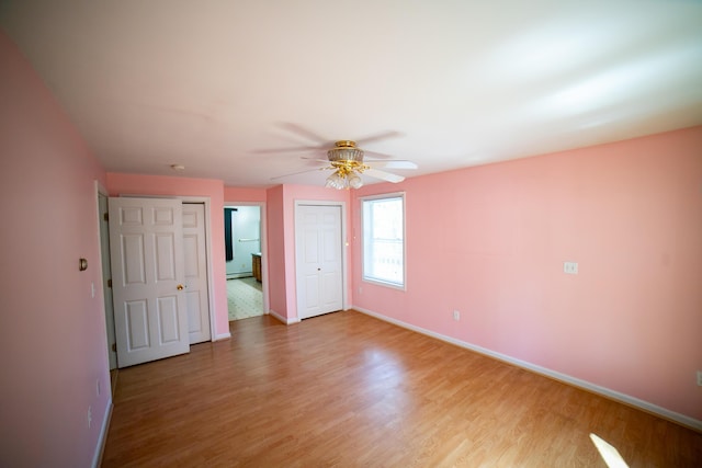 unfurnished bedroom with light wood-style floors, baseboards, ceiling fan, and baseboard heating