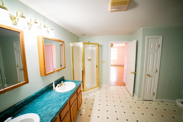 bathroom featuring double vanity, a sink, tile patterned floors, and a stall shower