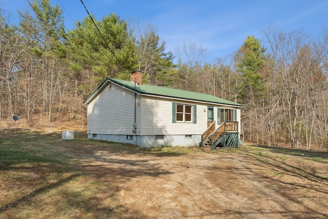 view of front of property with a chimney and metal roof