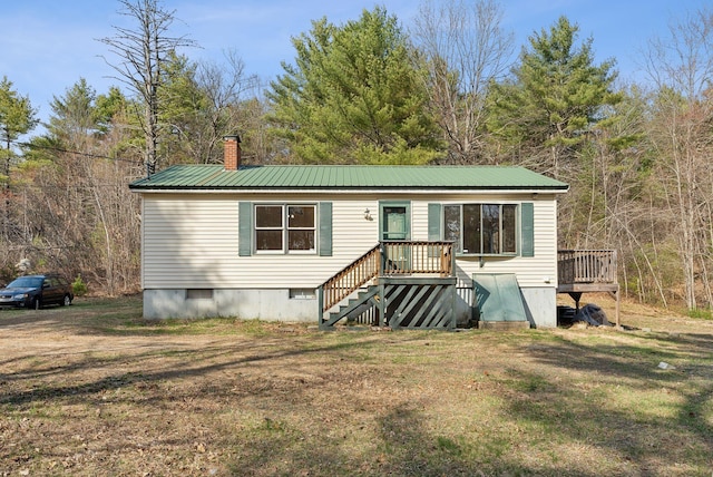 manufactured / mobile home with a wooden deck, a front yard, a chimney, crawl space, and metal roof