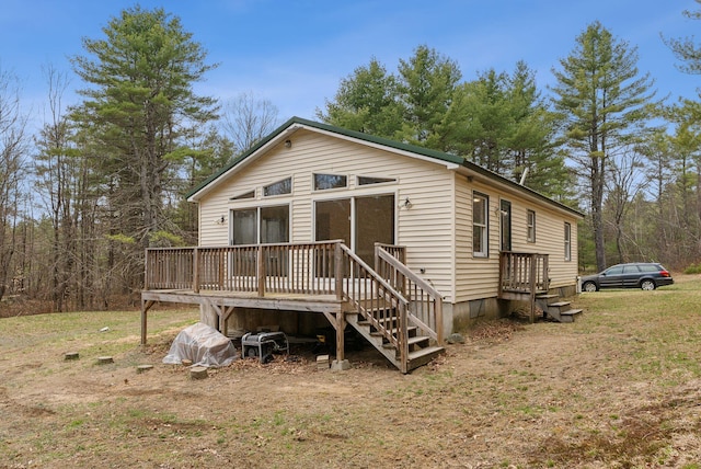 view of front of home featuring a wooden deck and a front yard