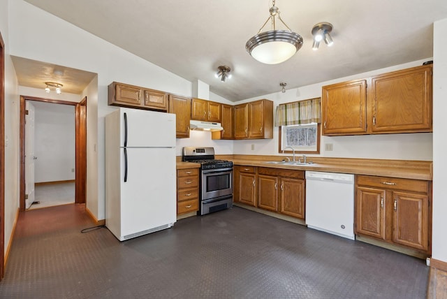kitchen with lofted ceiling, white appliances, under cabinet range hood, brown cabinets, and a sink