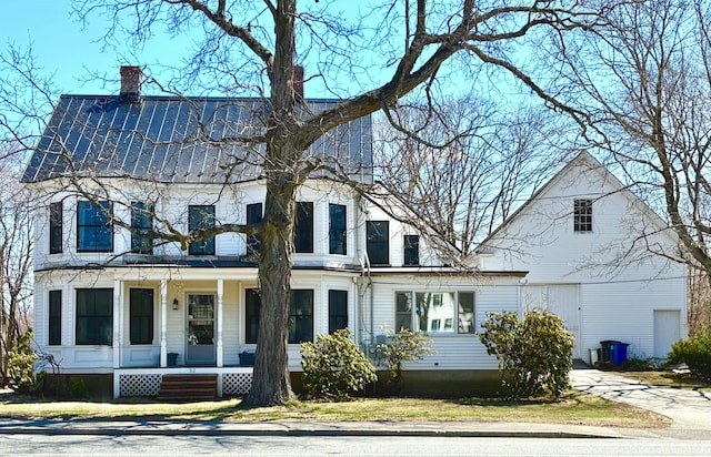 view of front of home with a chimney and covered porch