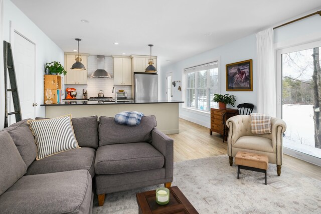 living room with baseboards, recessed lighting, and light wood-type flooring