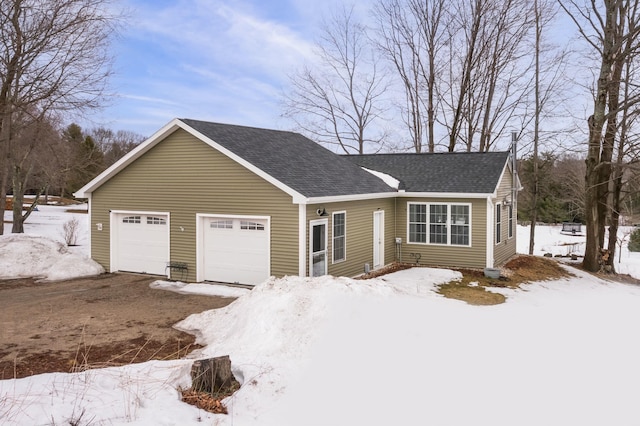 view of front facade with an attached garage and roof with shingles