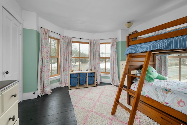 bedroom with baseboards and dark wood-style flooring