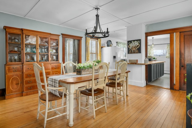 dining room with light wood-type flooring and a chandelier