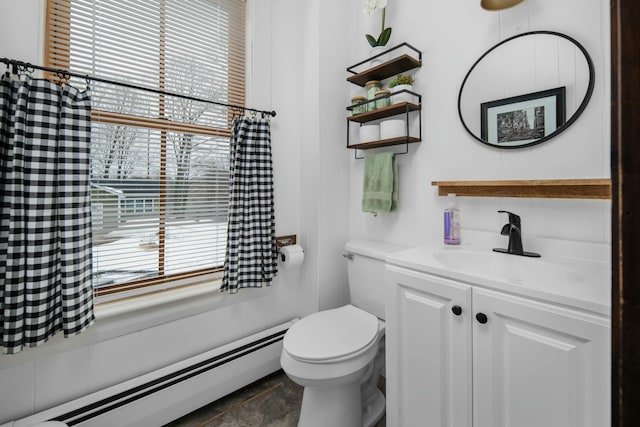 bathroom featuring a baseboard heating unit, plenty of natural light, vanity, and toilet