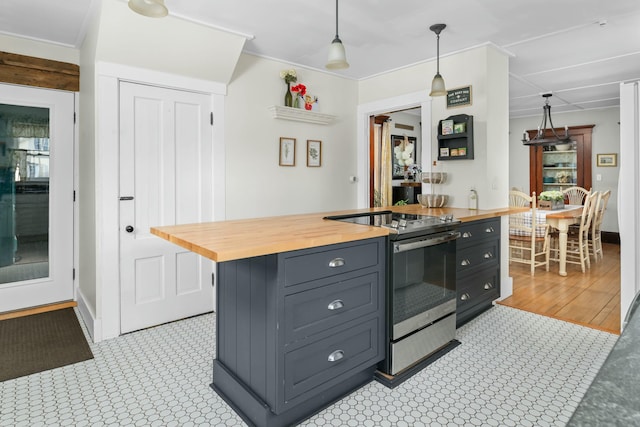 kitchen with stainless steel electric stove, baseboards, pendant lighting, and wooden counters