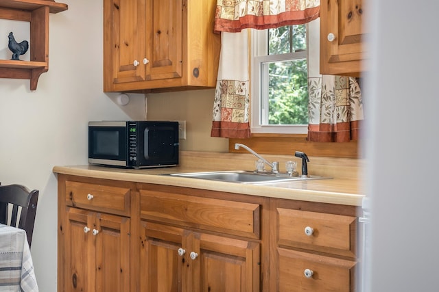 76 Cottage Shore Dr, Holden, ME 04429 - kitchen with open shelves, black microwave, light countertops, brown cabinets, and a sink