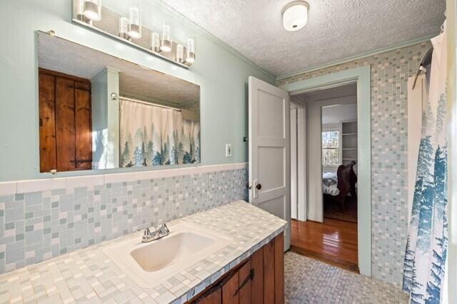 5 Paddy Creek Rd Unit 5, Kennebunkport, ME 04046 - bathroom featuring vanity, ornamental molding, a textured ceiling, a shower with curtain, and tile walls