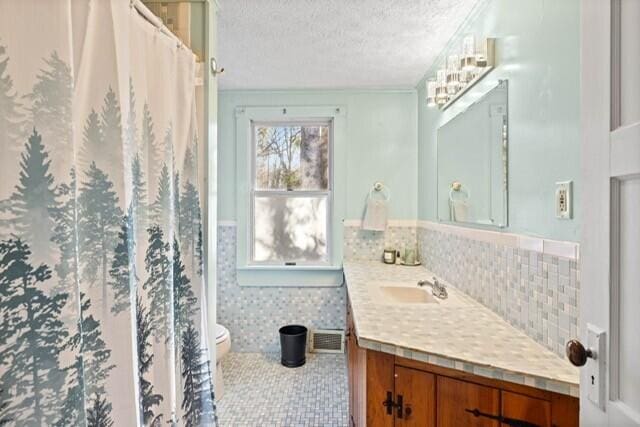 5 Paddy Creek Rd Unit 5, Kennebunkport, ME 04046 - full bath featuring vanity, a textured ceiling, a shower with shower curtain, and backsplash