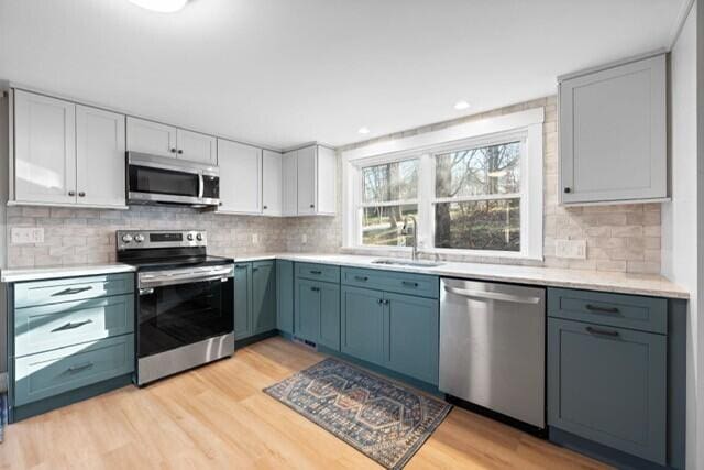 5 Paddy Creek Rd Unit 5, Kennebunkport, ME 04046 - kitchen featuring stainless steel appliances, light wood finished floors, light countertops, backsplash, and recessed lighting