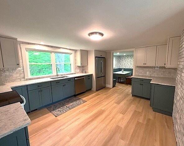 5 Paddy Creek Rd Unit 5, Kennebunkport, ME 04046 - kitchen featuring appliances with stainless steel finishes, backsplash, light wood-style floors, light countertops, and gray cabinets