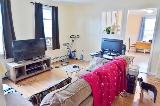 28 Cutts St, Biddeford, ME 04005 - living area with a baseboard heating unit, healthy amount of natural light, wood finished floors, and ornamental molding