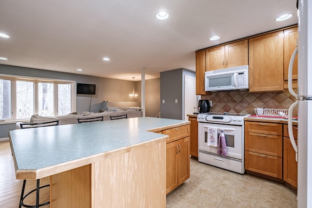 kitchen featuring white appliances, recessed lighting, light tile patterned floors, tasteful backsplash, and a kitchen island