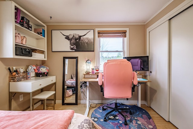 bedroom with crown molding, light wood-style flooring, and a closet
