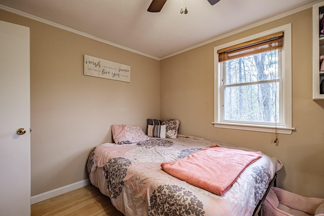 bedroom featuring baseboards, ceiling fan, ornamental molding, and wood finished floors