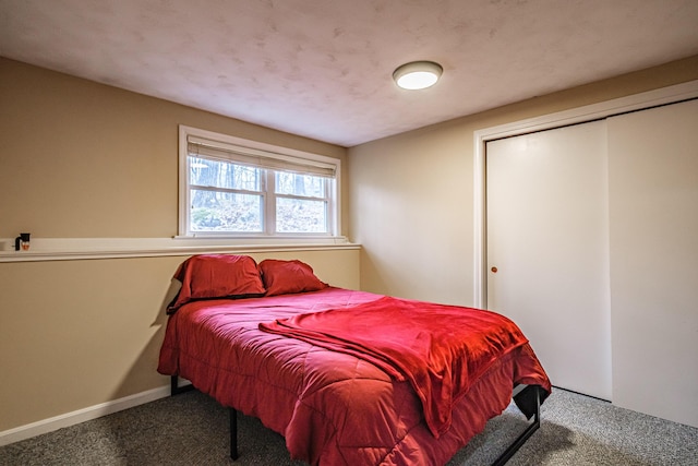 carpeted bedroom featuring a closet and baseboards