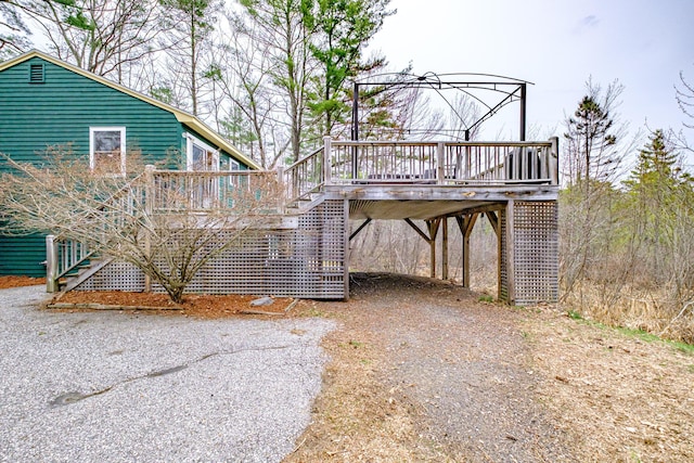 exterior space featuring a carport, a deck, and stairway