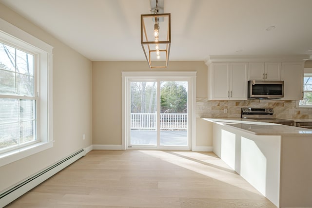 48 Highland Ave, Scarborough, ME 04074 - kitchen featuring a baseboard heating unit, stainless steel appliances, light wood-type flooring, backsplash, and light countertops