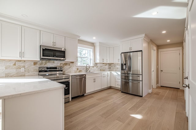 48 Highland Ave, Scarborough, ME 04074 - kitchen with white cabinets, stainless steel appliances, light wood-style floors, and light stone counters