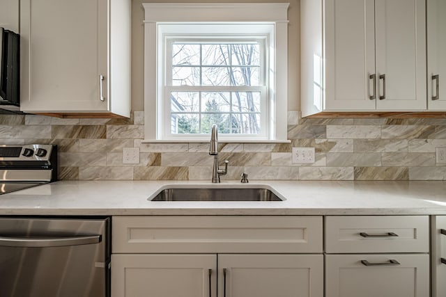 48 Highland Ave, Scarborough, ME 04074 - kitchen featuring light stone countertops, stainless steel dishwasher, decorative backsplash, and a sink