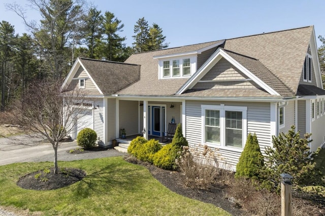 view of front facade featuring a porch, a front lawn, a garage, and roof with shingles