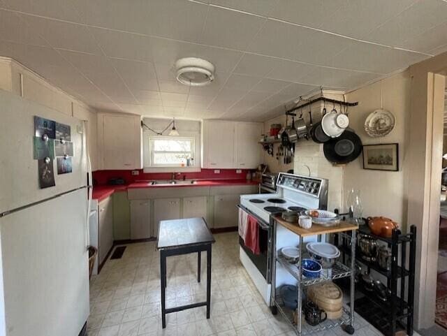 kitchen featuring light floors, dark countertops, visible vents, a sink, and white appliances