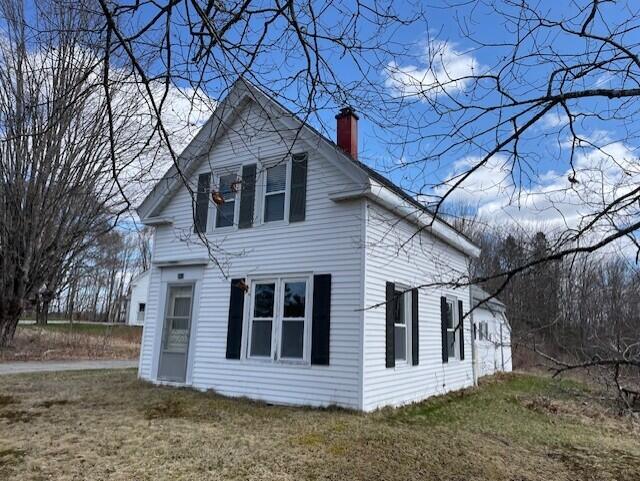 view of property exterior featuring a lawn and a chimney