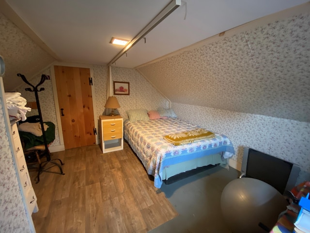 1361 Pleasant St, Blue Hill, ME 04614 - bedroom with vaulted ceiling, wood finished floors, and wallpapered walls