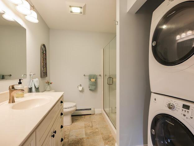 14 Connor Dr Unit 14, Gorham, ME 04038 - full bathroom with visible vents, stacked washer / drying machine, a shower stall, vanity, and a baseboard radiator