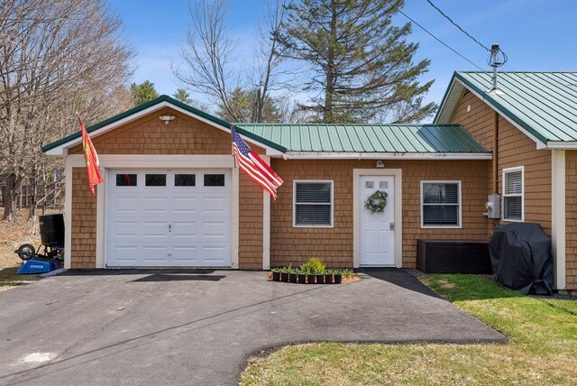 view of front of property with metal roof and driveway