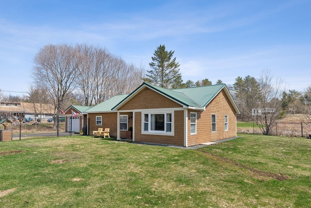 rear view of house with a lawn and fence
