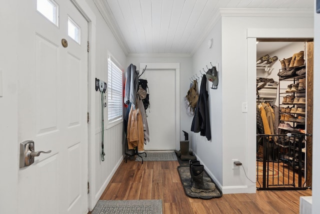 foyer with baseboards, wooden ceiling, ornamental molding, and wood finished floors