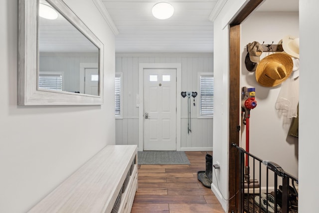foyer entrance featuring crown molding and dark wood finished floors