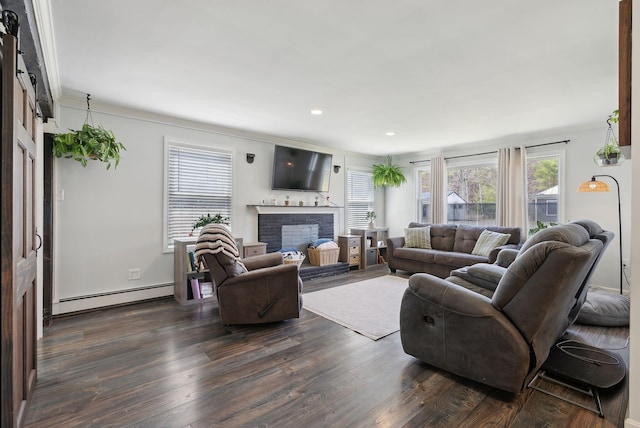 living room with dark wood-style floors, baseboard heating, and plenty of natural light