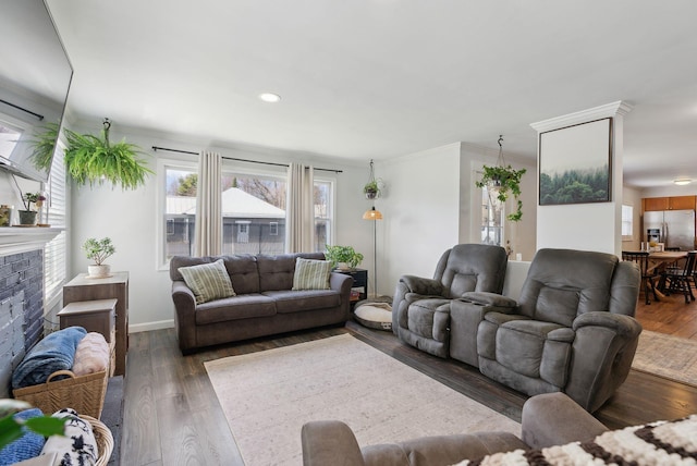 living room featuring recessed lighting, a brick fireplace, crown molding, baseboards, and wood finished floors